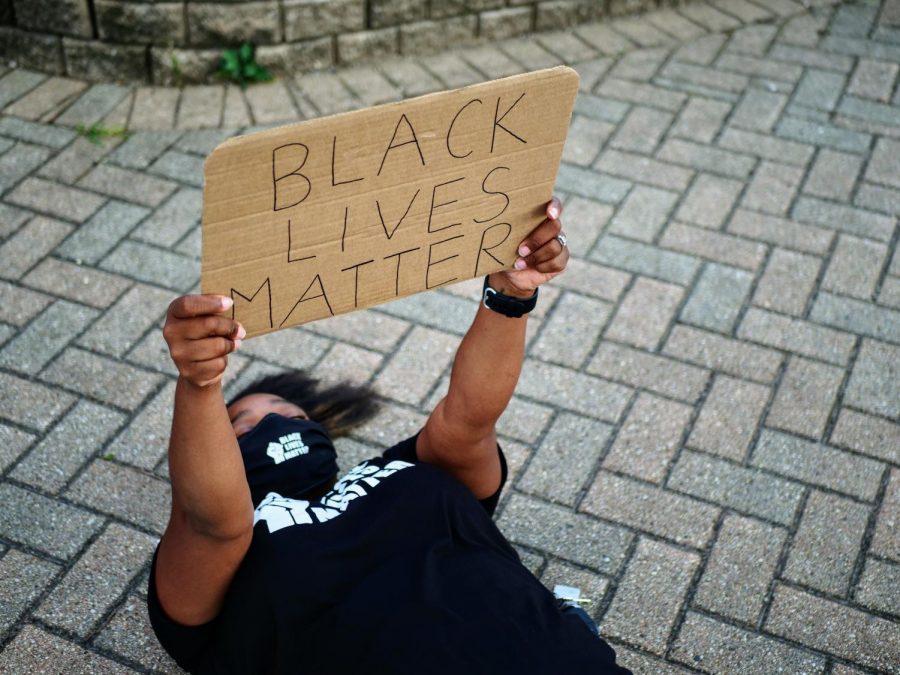 Black Lives Matter protester, Jessica holds a sign as she participates in a die-in protest in Memorial Park on Thursday July 23, 2020.