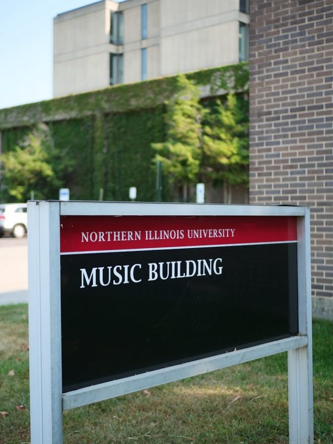 Music building sign stands in the grass along Lucinda Avenue in DeKalb. 