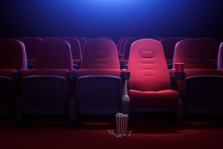 Interior of empty dark cinema with rows of red seats with cup holders and popcorn. Concept of entertainment. 3d rendering toned image