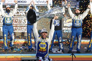 Chase Elliott holds up the season championship trophy as he celebrates with his race crew in Victory Lane after winning a NASCAR Cup Series auto race at Phoenix Raceway, Sunday, Nov. 8, 2020, in Avondale, Ariz.