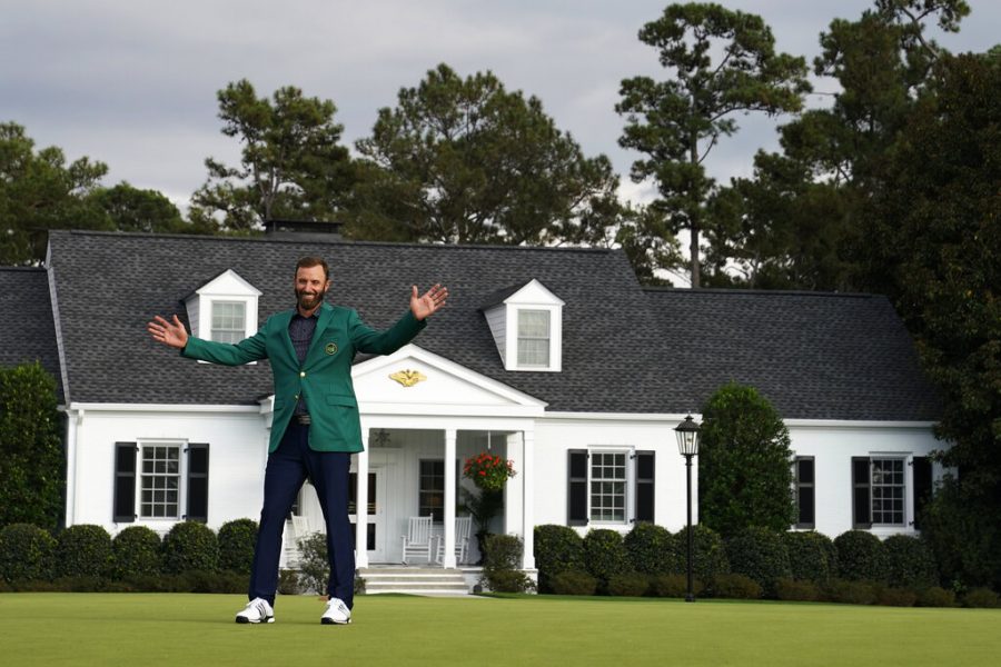 Masters golf champion Dustin Johnson poses in front of the Augusta National Golf Course clubhouse following his victory Sunday, Nov. 15, 2020, in Augusta, Ga.