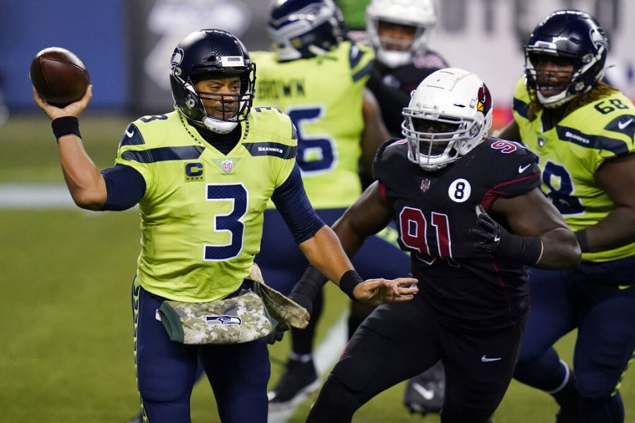 Seattle Seahawks quarterback Russell Wilson passes under pressure from Arizona Cardinals defensive end Michael Dogbe (91) during the first half of an NFL football game, Thursday, Nov. 19, 2020, in Seattle.