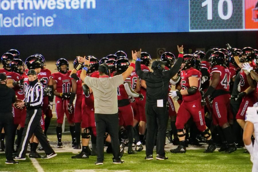 NIU football personnel  communicate with the team on the sideline Nov. 4, during NIUs 49-30 loss to the University at Buffalo Bulls at Huskie Stadium.