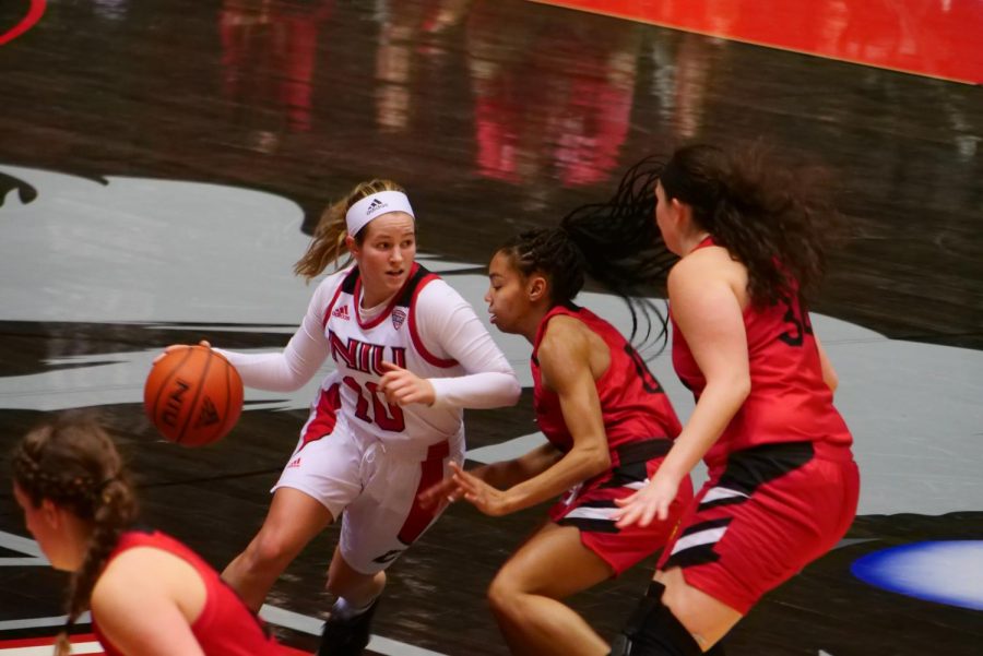 Sophomore guard Chelby Koker (left) drives past two defenders Nov. 25, during NIUs 85-61 loss to IUPUI at the NIU Convocation Center in DeKalb, Illinois. Koker scored a career-high 21 points in NIUs season opener.