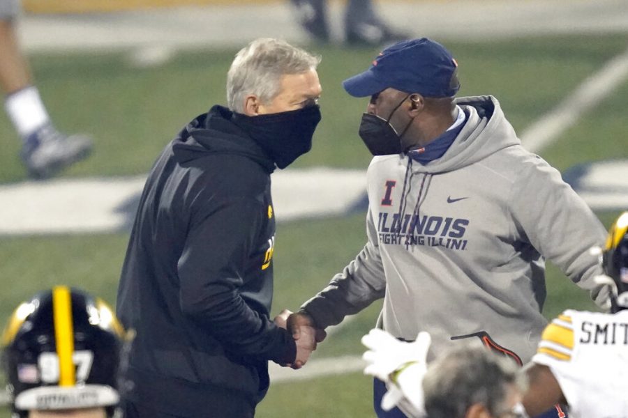 Iowa head coach Kirk Ferentz, left, and Illinois head coach Lovie Smith shakes hands after an NCAA college football game Saturday, Dec. 5, 2020, in Champaign, Ill. Iowa won 35-21.