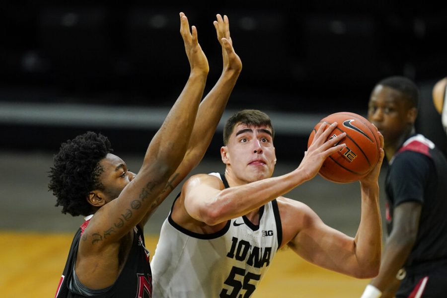Iowa center Luka Garza drives to the basket ahead of Northern Illinois forward Chinedu Okanu, left, during the first half of an NCAA college basketball game, Sunday, Dec. 13, 2020, in Iowa City, Iowa. 