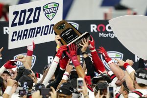 Ball State players reach for the trophy after defeating Buffalo in the Mid-American Conference championship NCAA college football game, Friday, Dec. 18, 2020, in Detroit.