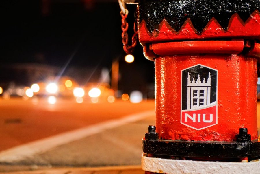 A NIU decorated fire hydrant sits grounded on the sidewalk at the intersection of First Street and Lincoln Highway in DeKalb.