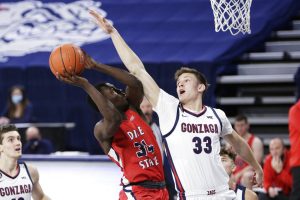 Dixie State guard Emad Elniel (34) shoots and is fouled by Gonzaga forward Ben Gregg (33) during the second half of an NCAA college basketball game in Spokane, Wash., Tuesday, Dec. 29, 2020. Gonzaga won 112-67.