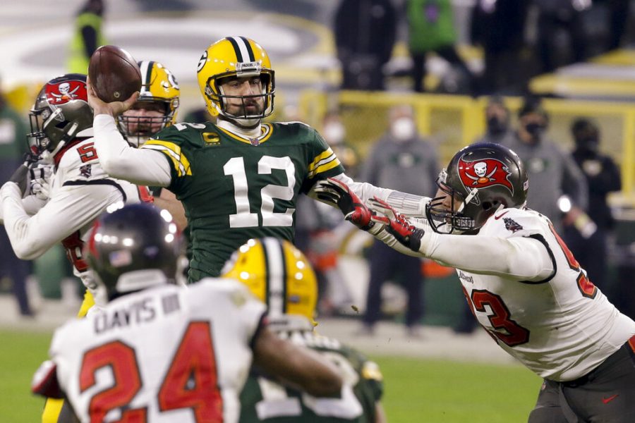 Green Bay Packers quarterback Aaron Rodgers (12) evades a tackle as he looks to pass against the Tampa Bay Buccaneers during the second half of the NFC championship NFL football game Jan. 24, 2021, in Green Bay, Wisconsin. 