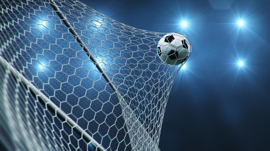 Soccer ball flies through the net in the goal.