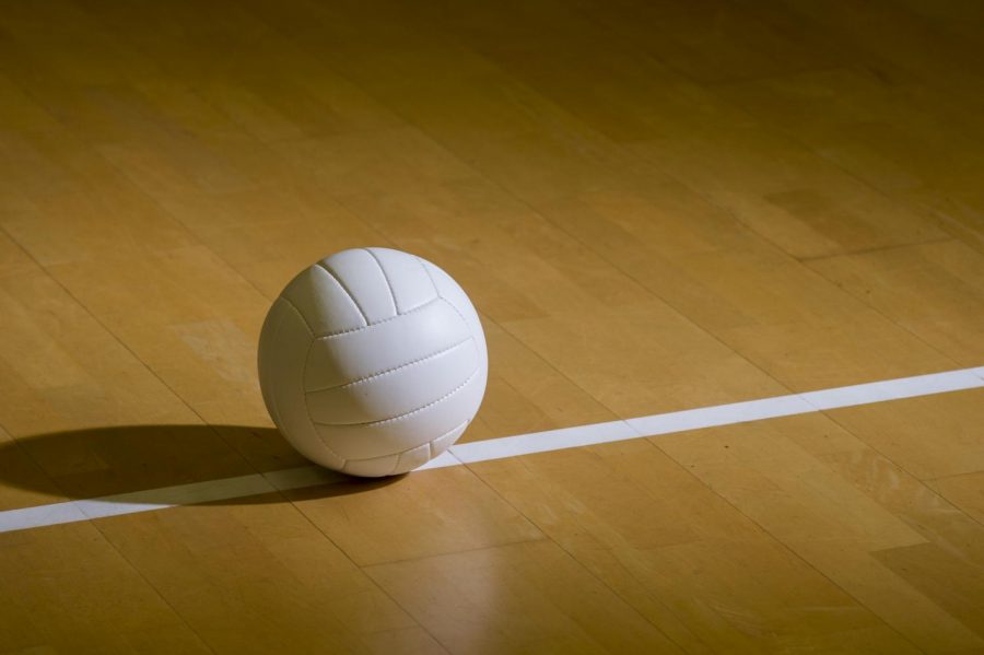 Volleyball on a wood court floor.