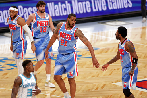 Brooklyn Nets center LaMarcus Aldridge (center) high-fives with guard Kyrie Irving (right) April 1, during the first half of the team's NBA basketball game against the Charlotte Hornets in New York. The Nets won 111-89.