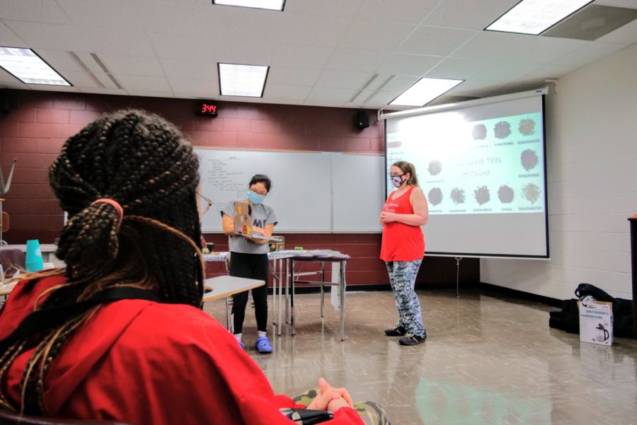 Chinese Club vice president Hannah Schaumberg holds a laptop so members attending virtually can see the presentation.