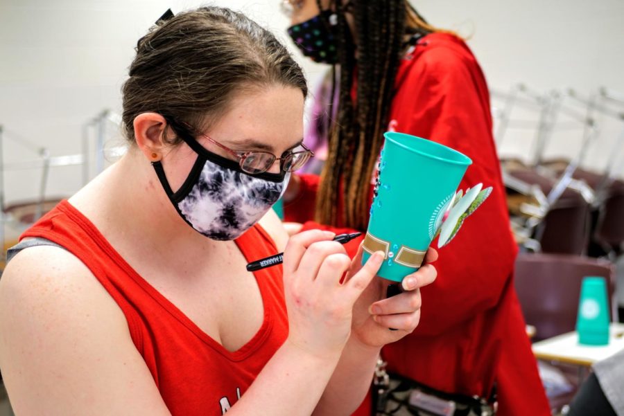 Sam Beightol draws on her personalized tea cup with a glitter pen.