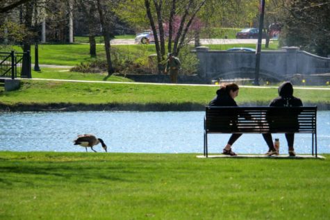 Two NIU students sit on a bench at the East Lagoon.