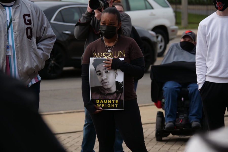 Jessica Webb, of DeKalb, holds a Daunte Wright sign on Friday during the vigil at Memorial Park. 