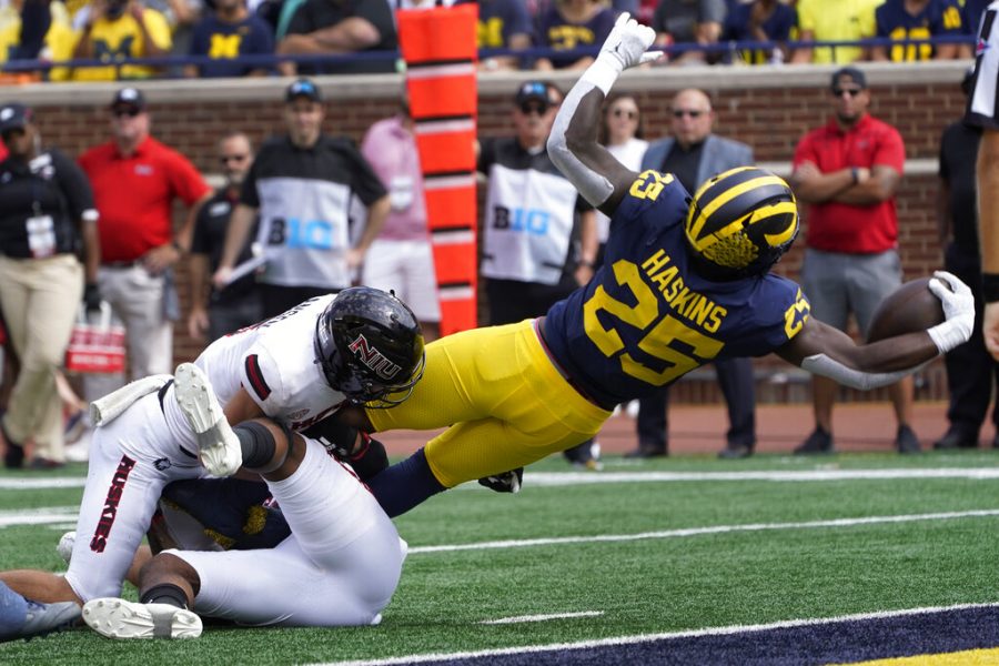 Michigan running back Hassan Haskins (25) dives into the end zone for a five-yard touchdown run against Northern Illinois in the first half of a NCAA college football game in Ann Arbor, Mich., Saturday, Sept. 18, 2021. 