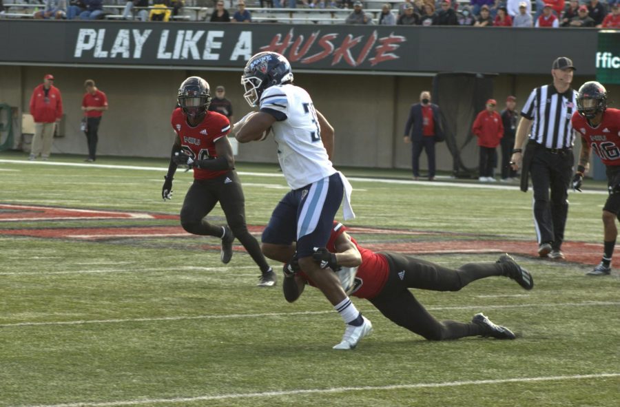Maine senior running back Jordan Rowell tries to evade an NIU tackle late at Huskie Stadium on Sept. 25. Rowell, the native of Elmhurst, had two carries for five yards in his return to Huskie Stadium.