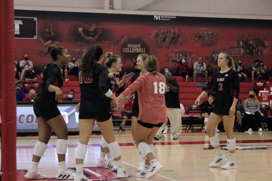 The NIU volleyball team celebrates after a kill against WIU on Aug. 27. The Huskies record now sits at 11-11.