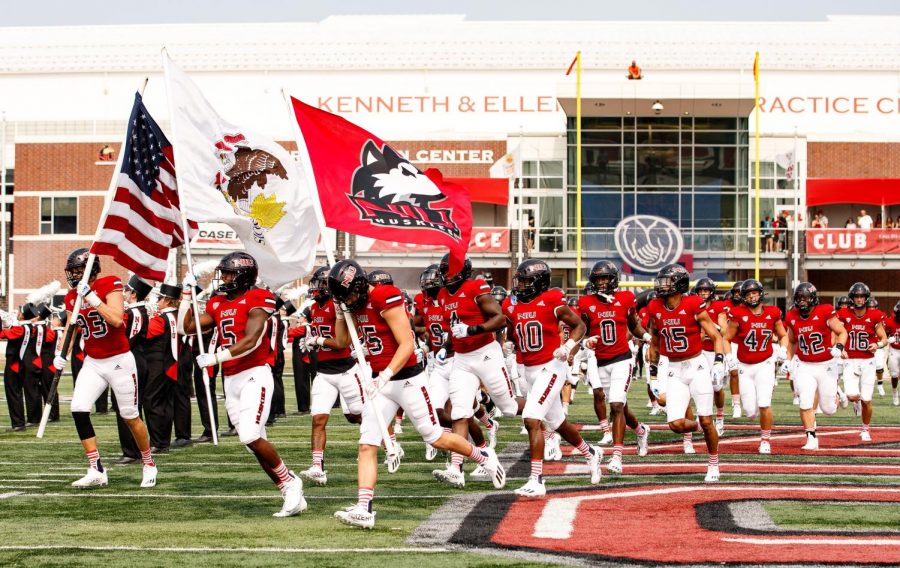The NIU football team runs onto the field at Huskie Stadium ahead of their game Sept. 11 against Wyoming.