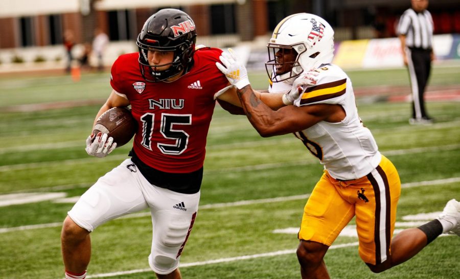 Redshirt junior wide reciever Cole Tucker fends off an attempted tackle by University of Wyoming junior safety Rome Weber during NIUs 2021 season opener on Sept. 11, 2021, in DeKalb. Tucker caught six passes for 72 yards as NIUs comeback came up short against the Cowboys. (Northern Star File Photo)