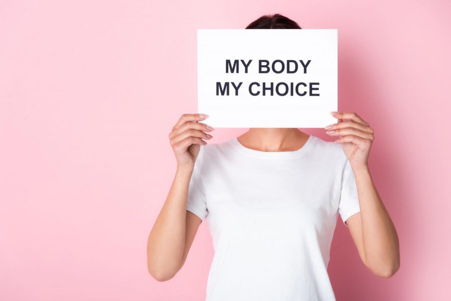 A person holding a sign, advocating for reproductive rights. 