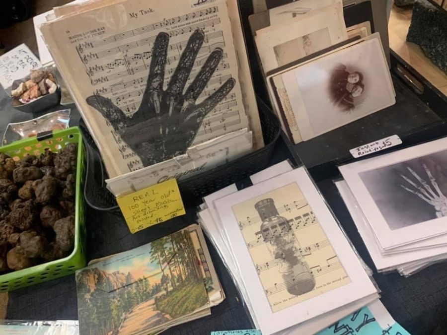 A vendor table displays horror antique art items for sale at the 2019 Dark Art and Oddities convention. 