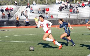 Graduate student forward Haley Hoppe dribbles past a defender during a match on Sept. 23. Hoppe is helping the next generation of womens soccer players while continuing to lead the Huskies offense.