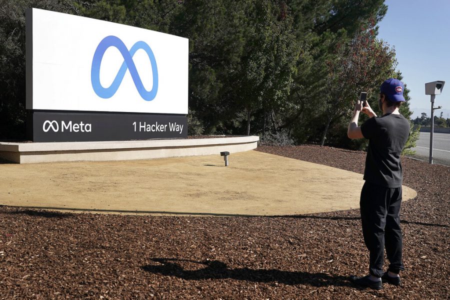 A Facebook employee takes a photo in front of the new Meta Platforms Inc. sign outside the company headquarters in Menlo Park, Calif. Facebook CEO Mark Zuckerberg announced the company name change Oct. 28 after the release of the Facebook papers.