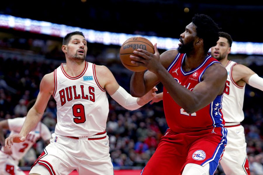 Philadelphia 76ers Joel Embiid looks to shoot as Chicago Bulls Nikola Vucevic (9) and Zach LaVine defend during the first half of an NBA basketball game Saturday, Nov. 6, 2021, in Chicago.