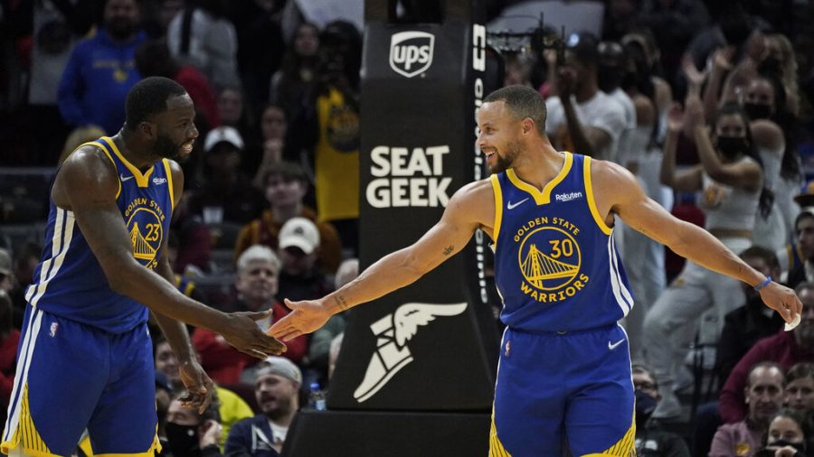 Golden State Warriors Stephen Curry (30) and Draymond Green celebrate late in the second half of an NBA basketball game against the Cleveland Cavaliers, Thursday, Nov. 18, 2021, in Cleveland. The Warriors won 104-89. 