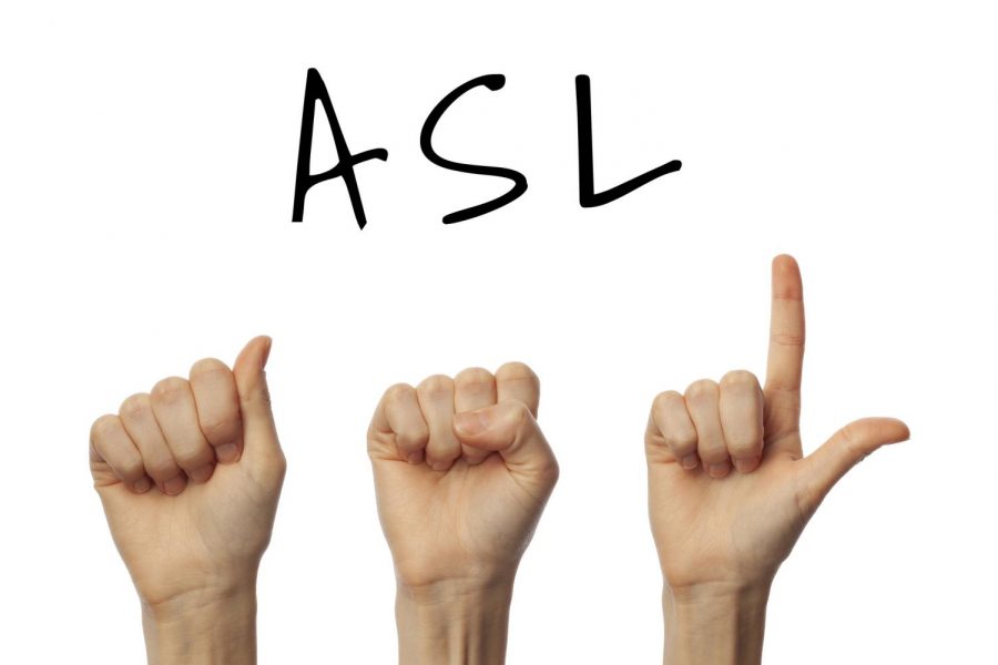 Three hands, signing ASL.