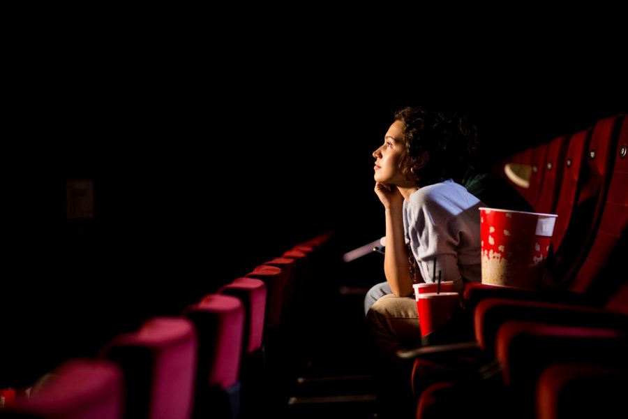Young woman enjoying a film at the cinema.