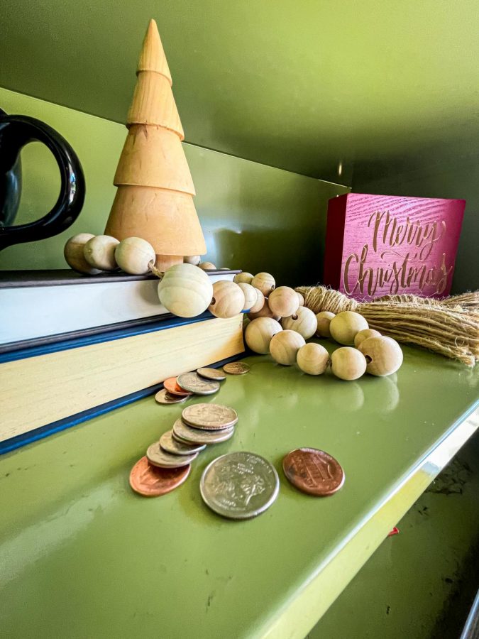 Various coins sit on a shelf. 