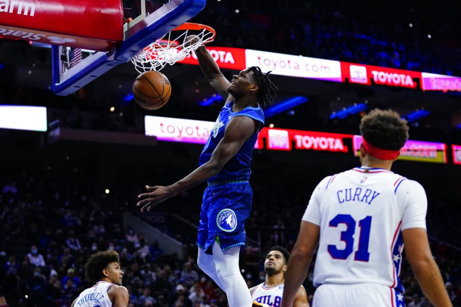 Minnesota Timberwolves Anthony Edwards, center, dunks the ball as Philadelphia 76ers Matisse Thybulle, from left,, Tobias Harris and Seth Curry look on during the first half of an NBA basketball game, Saturday, Nov. 27, 2021, in Philadelphia. 