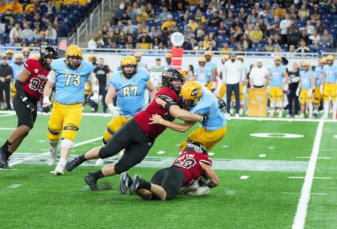 Freshman defensive tackle Cade Haberman and sophomore Nick Rattin wrap up Kent State graduate student Dustin Crum for a sack on Dec. 4 in Detroit.