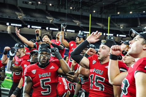 NIU players celebrate in front of their fans after their 41-23 victory over Kent State on Dec. 4 in Detroit. The Huskies become the first team in FBS history to win a conference championship game after going winless the year prior. (Wes Sanderson | Northern Star)