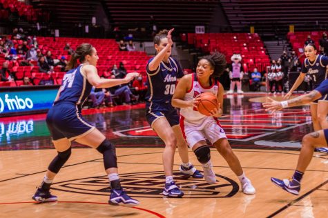 Akron defenders guard against redshirt senior guard Janae Poisson at the NIU Convocation Center on Feb. 8. (Summer Fitzgerald | Northern Star)