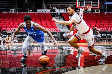NIU senior guard Trendon Hankerson (right) and Buffalo senior forward Jeenathan Williams surge in an attempt to recover the ball during Thursdays home matchup against the University at Buffalo. The Huskies fell to the Bulls in back-to-back games, losing 79-68 Thursday and 70-60 Saturday. (Zohair Khan | Northern Star)