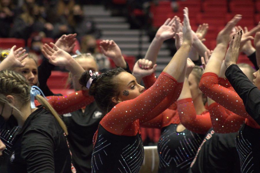 Senior Morgan Hooper (center) celebrates with teammates after completing her performance on the balance beam at the NIU Tri-Meet Friday at the Convocation Center in DeKalb. Hooper competed in all four events, finishing within the top-5 on vault, balance beam and floor exercise. (Sean Reed/Northern Star)