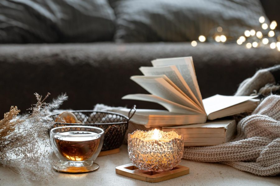 Cozy home composition with cup of tea, candlestick and books close up (Getty Images)