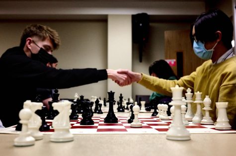 Sophomore applied mathematics major and statistics major Ace Frieders (left) and sophomore math education major Dylan Ruan (right) shake hands during a casual game at the Chess Club. The Chess Club meets every Monday at 7:30 p.m. in room 450 in the Holmes Student Center. 