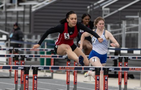 Sophomore runner Scout Regular (left) jumps over a hurdle during the 100-meter hurdles event Saturday at the Illini Classic at Demirijan Park Stadium in Urbana, Illinois. Scout recorded a time of 14.32 seconds to take first place in the event, alongside three other NIU first-place finishes.