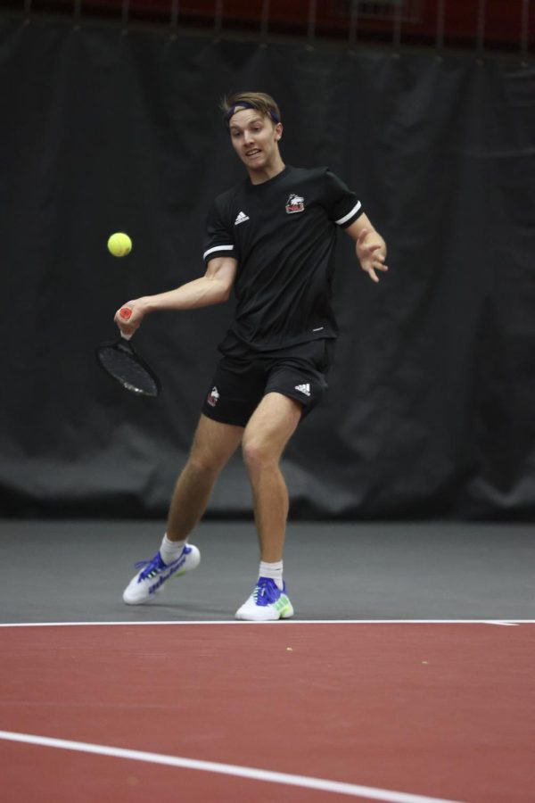 Junior tennis player Oliver Valentinsson swing his racket at a tennis ball during a match against Binghamton University April 1 in DeKalb.