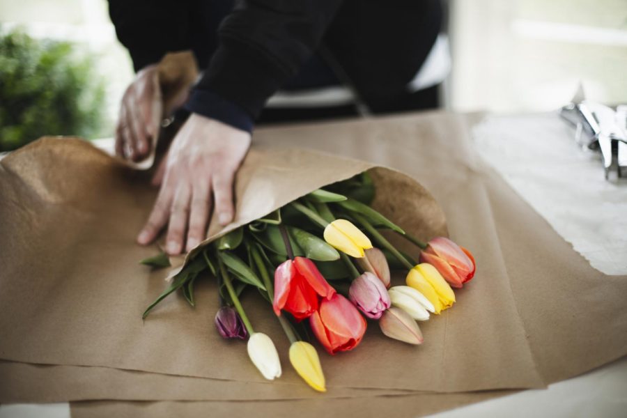 Bunch of rainbow tulips in brown paper wrap (Getty Images)