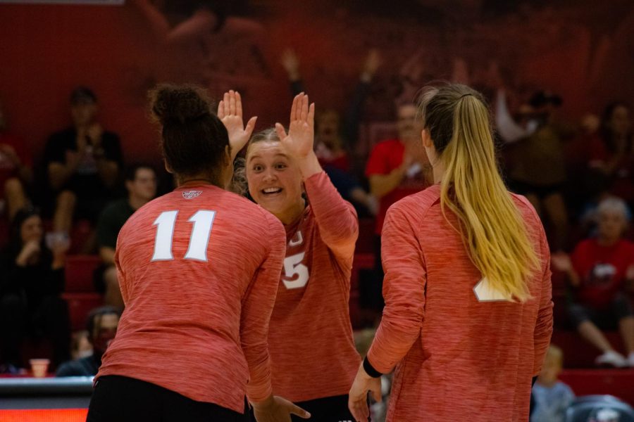 (Left to right) Charli Atiemo, Ella Mihacevich and Katie Jablonski celebrate a point scored in the final set vs. South Dakota State on Friday.  (Sean Reed | Northern Star)