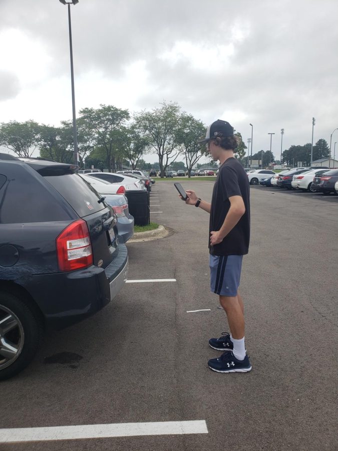 History major Eddie Hoffman navigates the new virtual parking permit system on his phone. This license plate recognition technology was recently introduced to NIU.