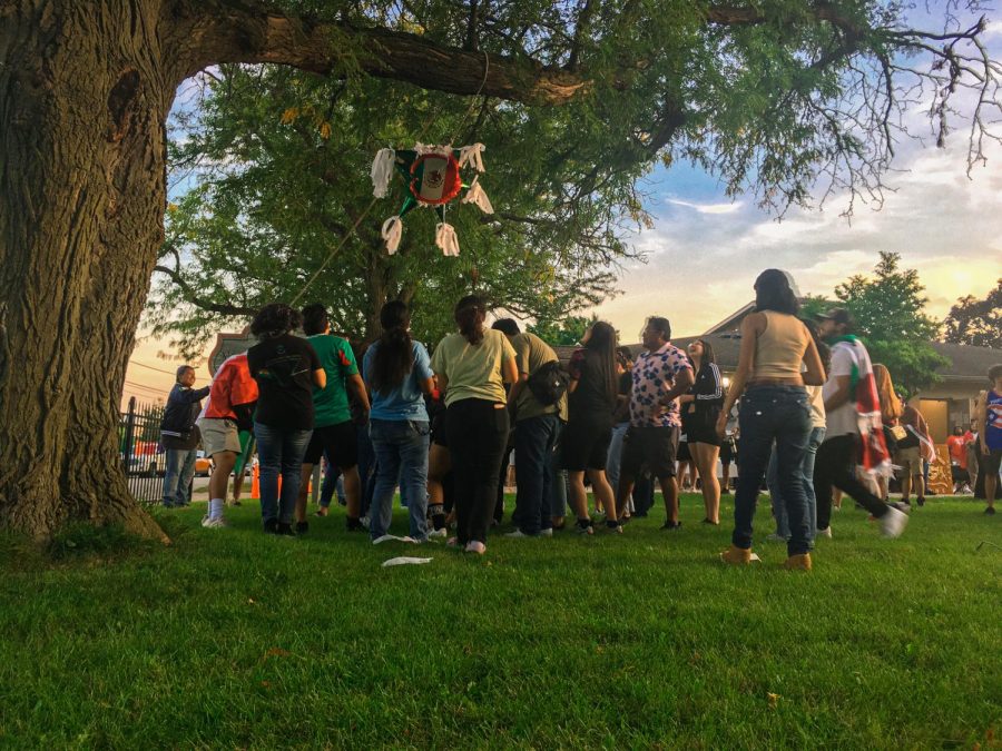 Attendees surrounding the piñata at El Grito as one participant attempts to break it open. The celebration of Latino Heritage Month will continue through mid-October, with events planned over the next month by the Latino Resource Center.