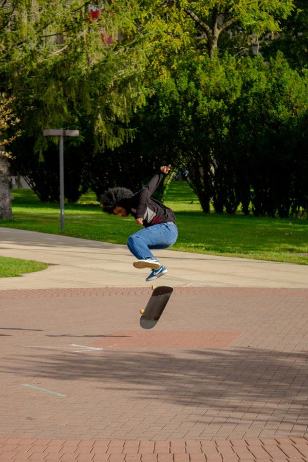 Nasir Suliman, NIU Sophomore, attempts skateboarding tricks in the MLK Commons, near the visitor pay lot, Monday evening. (Sean Reed | Northern Star)